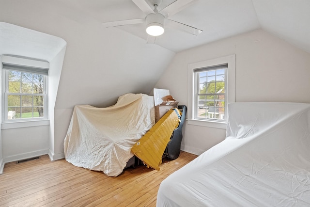 bedroom with light wood finished floors, lofted ceiling, visible vents, and multiple windows