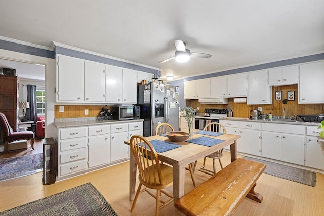 kitchen with a ceiling fan, a sink, stainless steel appliances, white cabinets, and light countertops