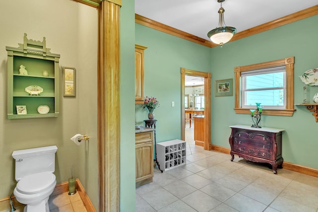 bathroom with crown molding, toilet, baseboards, and tile patterned flooring