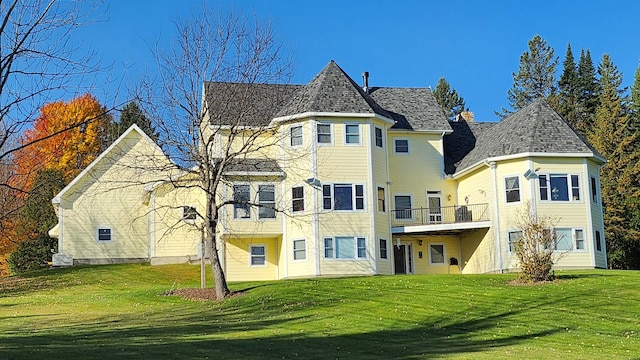 rear view of house featuring a lawn