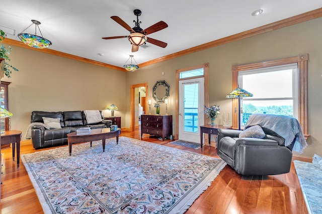 living room with ceiling fan, crown molding, baseboards, and light wood finished floors