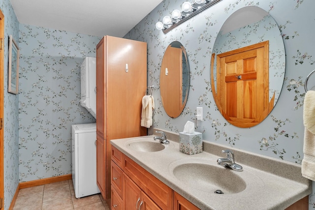 full bath with a sink, tile patterned flooring, stacked washer and dryer, and wallpapered walls