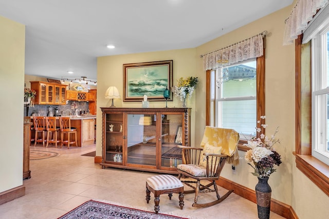 living area with light tile patterned floors, recessed lighting, baseboards, and indoor bar