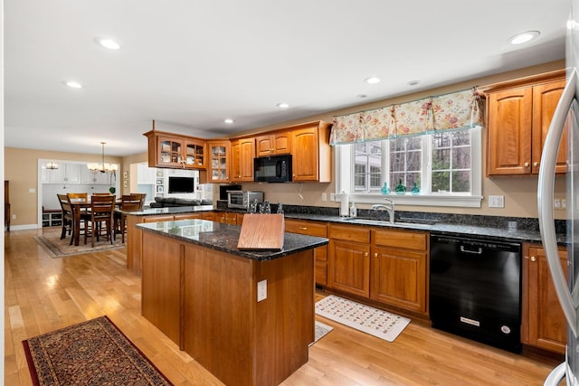 8 Palis Dr, Salisbury, MA 01952 - kitchen featuring a sink, brown cabinets, black appliances, a center island, and glass insert cabinets