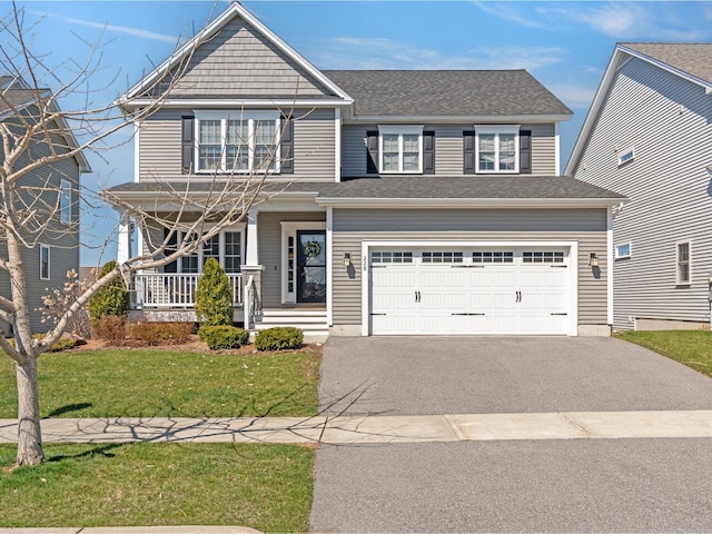 craftsman house with covered porch, aphalt driveway, a garage, and a front yard