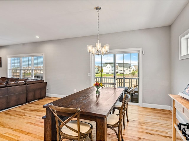 dining space featuring a notable chandelier, light wood finished floors, and plenty of natural light