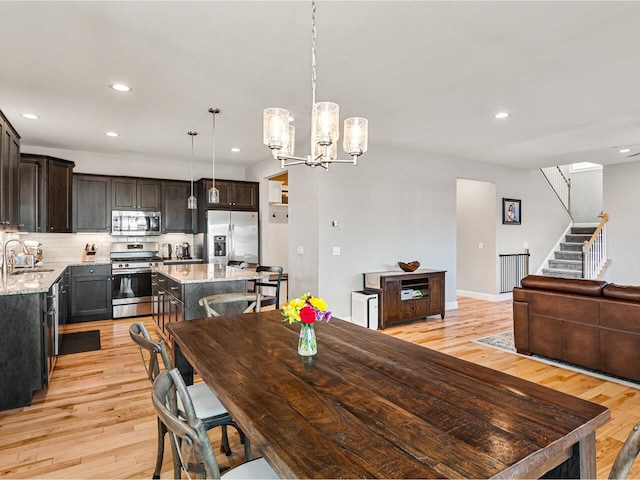 dining area with light wood-style floors, a chandelier, stairway, and recessed lighting