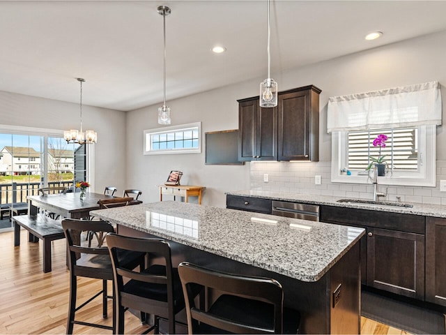 kitchen with plenty of natural light, dark brown cabinets, and a sink