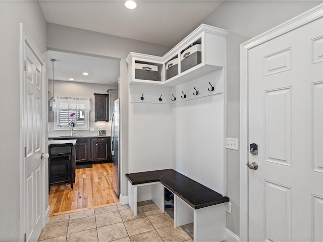 mudroom with baseboards, recessed lighting, and a sink