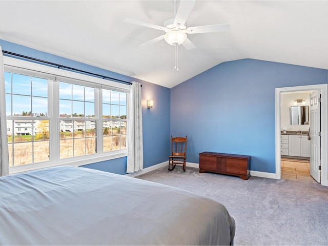 bedroom featuring vaulted ceiling, ensuite bathroom, carpet floors, and baseboards