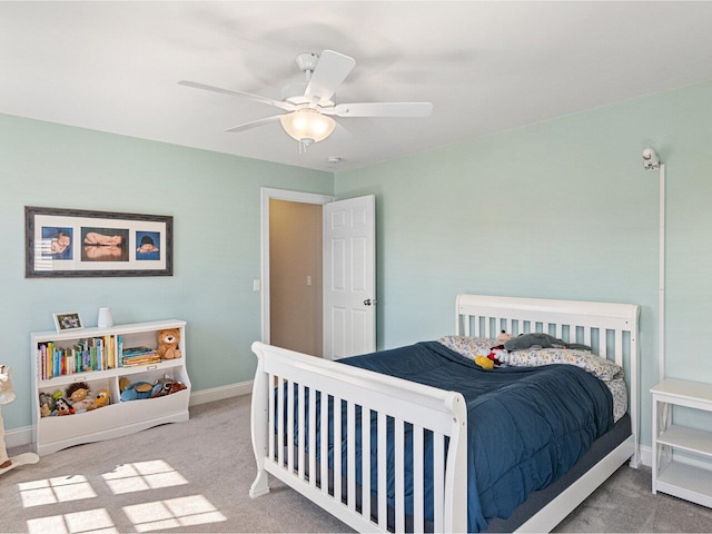 carpeted bedroom featuring baseboards and a ceiling fan