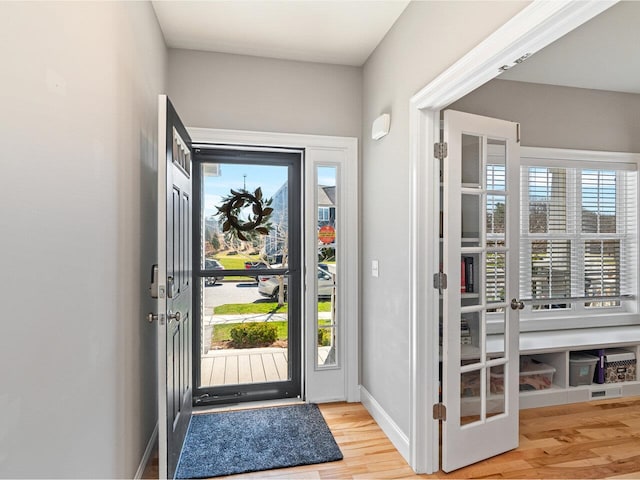 doorway featuring baseboards and wood finished floors