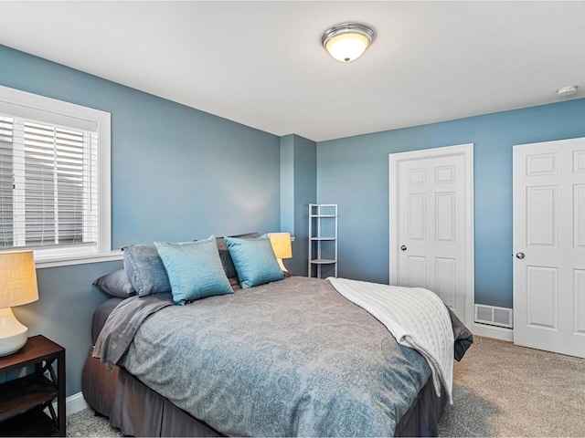 carpeted bedroom featuring baseboards and visible vents