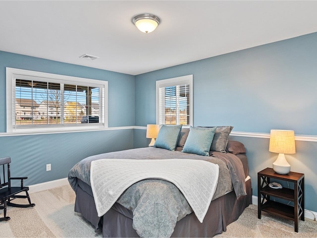 carpeted bedroom featuring visible vents and baseboards