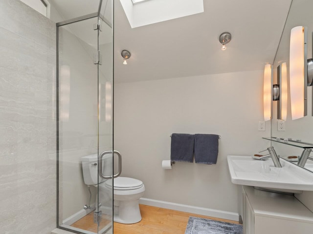 25 Oakledge Dr, Burlington, VT 05401 - bathroom featuring a stall shower, toilet, a sink, wood finished floors, and a skylight
