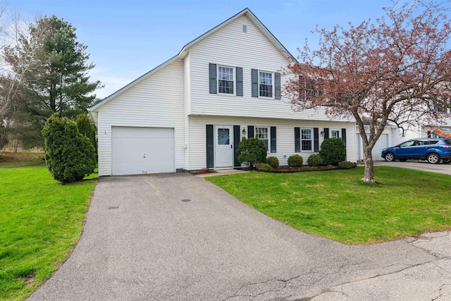 view of front of house with a front lawn, aphalt driveway, and a garage