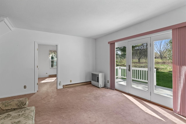 interior space with a baseboard radiator, a baseboard heating unit, and carpet floors
