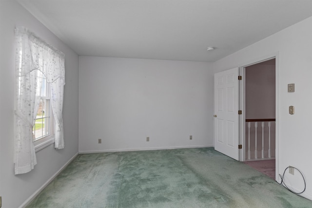 carpeted empty room featuring baseboards