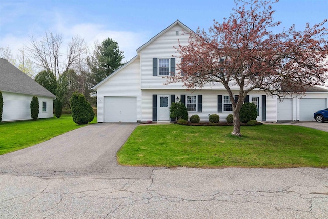 view of front facade with an attached garage, a front yard, and aphalt driveway