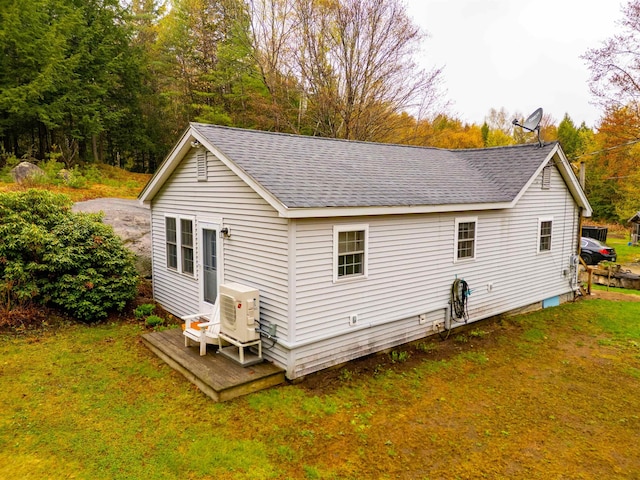 exterior space featuring ac unit, a deck, roof with shingles, and a yard