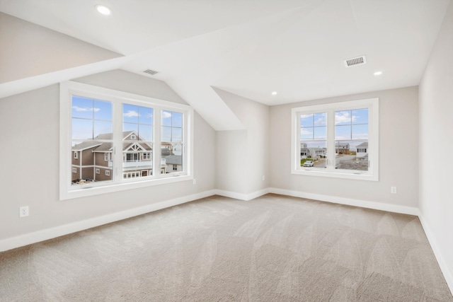 additional living space with visible vents, baseboards, lofted ceiling, and carpet floors