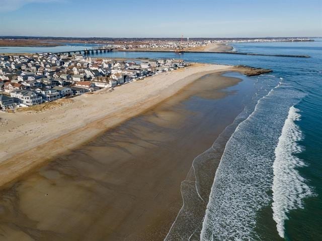 birds eye view of property featuring a beach view, a water view, and a residential view