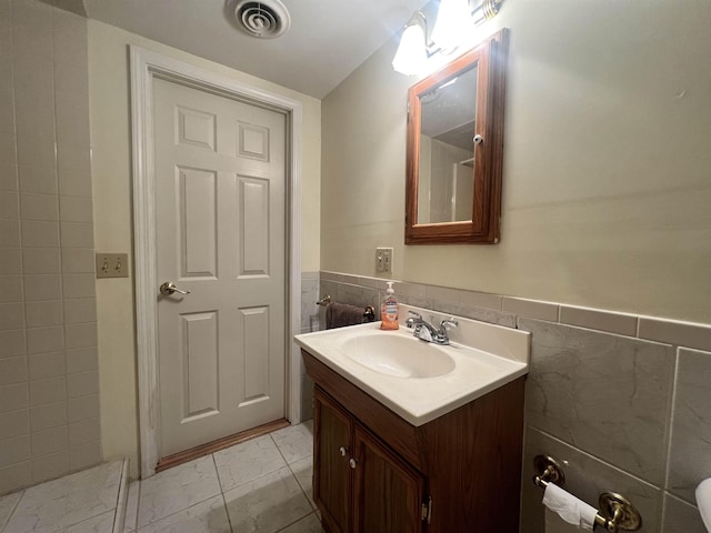 bathroom with vanity, tile walls, marble finish floor, and visible vents