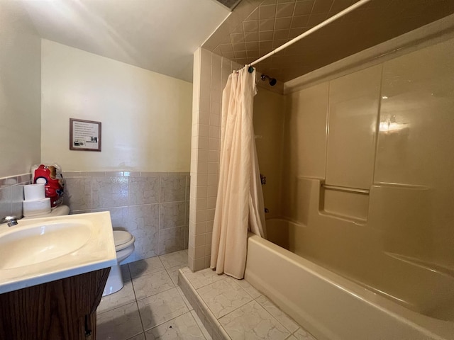 full bath with tile walls, toilet, marble finish floor, vanity, and shower / tub combo with curtain