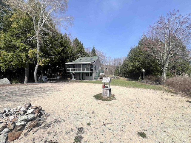 view of yard with stairs, a wooden deck, and a sunroom