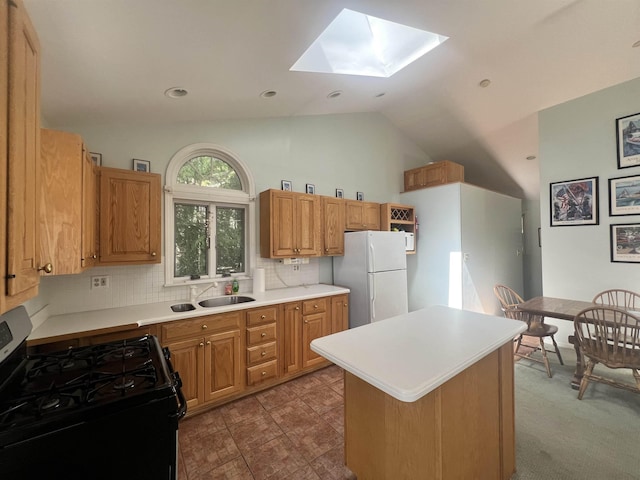 kitchen with a sink, freestanding refrigerator, gas stove, decorative backsplash, and light countertops
