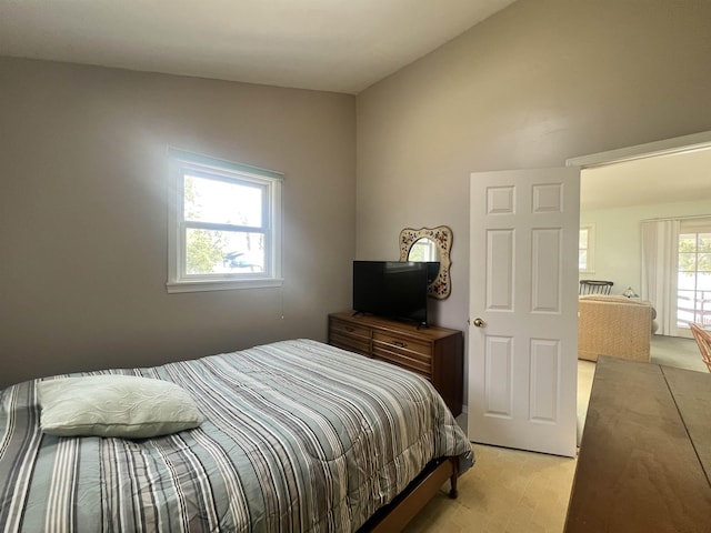 bedroom featuring lofted ceiling and light carpet