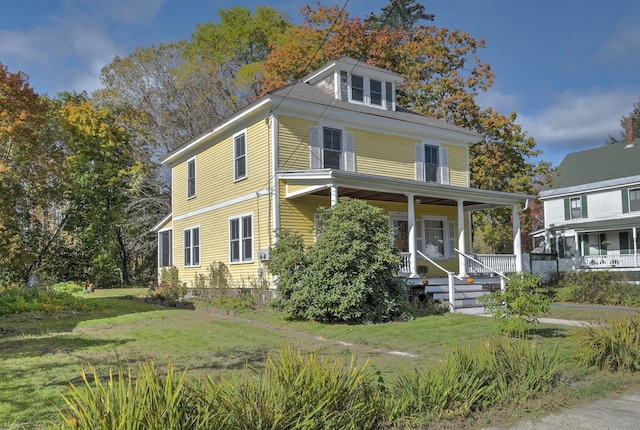 american foursquare style home with covered porch and a front lawn
