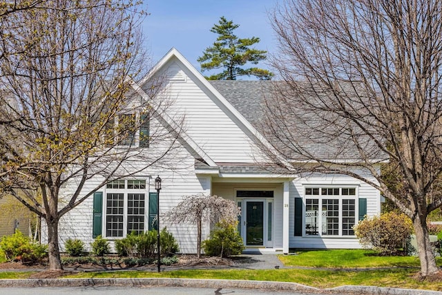 view of front facade featuring a front yard and roof with shingles