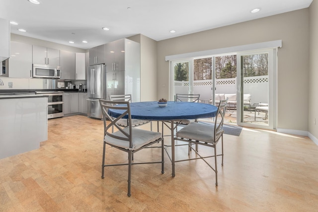 dining area with baseboards, light wood-type flooring, and recessed lighting