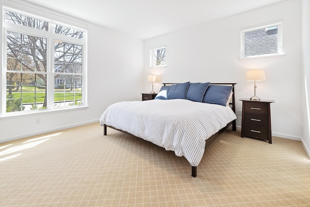 bedroom with baseboards and light carpet