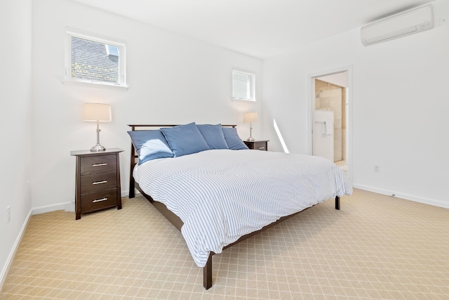bedroom with light colored carpet, ensuite bathroom, a wall mounted AC, and baseboards