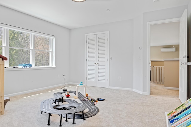 game room featuring baseboards, carpet, and an AC wall unit
