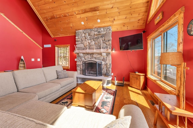 living area featuring wood ceiling, wood finished floors, a fireplace, baseboards, and vaulted ceiling