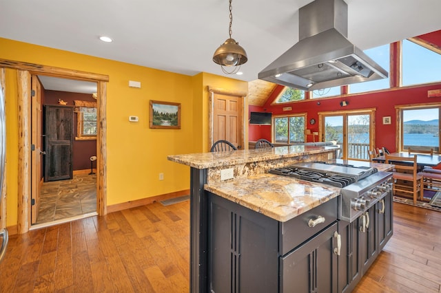 kitchen with a center island, stainless steel gas stovetop, baseboards, island range hood, and light wood-style floors