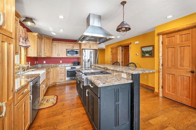kitchen featuring a sink, stainless steel appliances, light wood finished floors, island range hood, and a center island