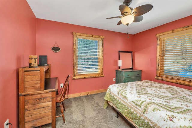 carpeted bedroom featuring baseboards, multiple windows, and ceiling fan