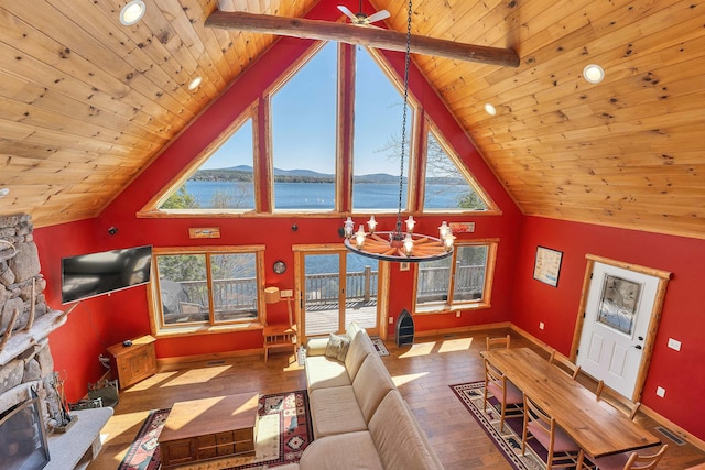 living area with baseboards, a wealth of natural light, and wooden ceiling