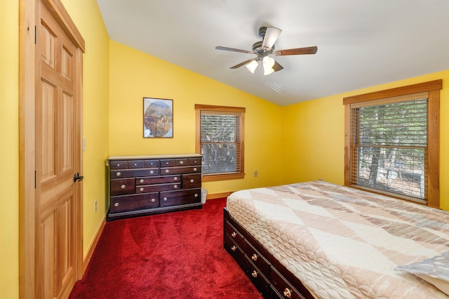 bedroom with multiple windows, dark colored carpet, baseboards, and lofted ceiling