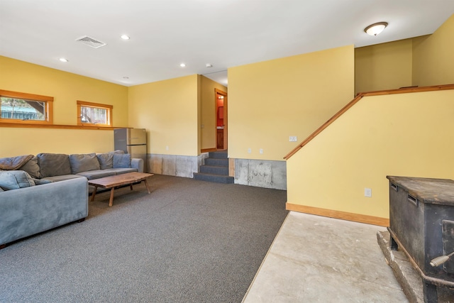 living area with finished concrete floors, visible vents, and recessed lighting