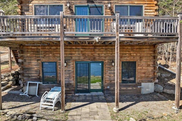 rear view of house featuring a deck and log exterior