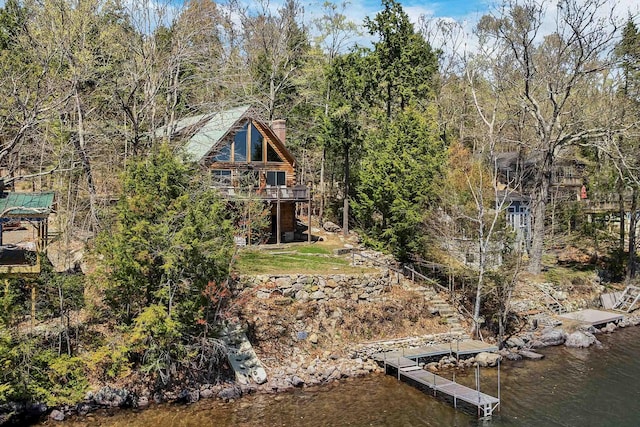 exterior space with a chimney and a deck with water view