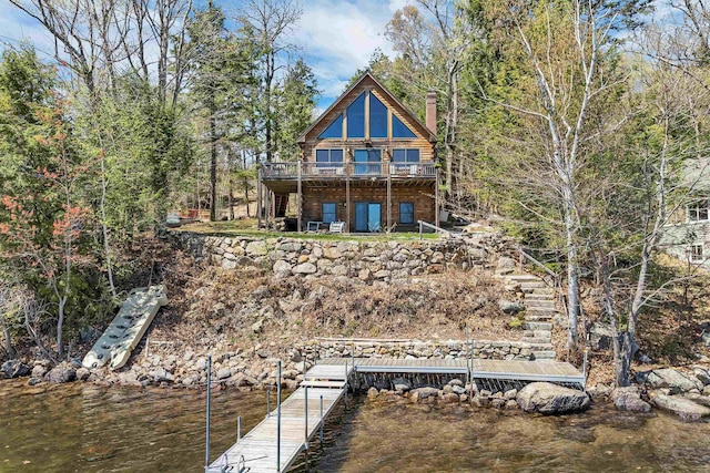 rear view of property with a chimney and a deck with water view