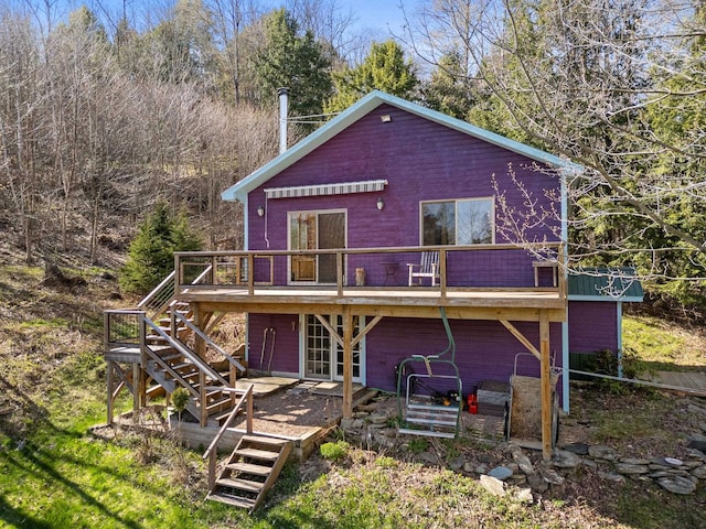 rear view of house with stairway and a wooden deck