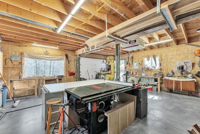 basement with a workshop area, a heating unit, and a healthy amount of sunlight