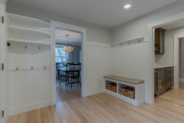 mudroom with a chandelier, baseboards, light wood-type flooring, and beverage cooler